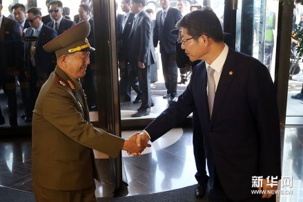 黄炳誓与韩国统一部长官柳吉在握手